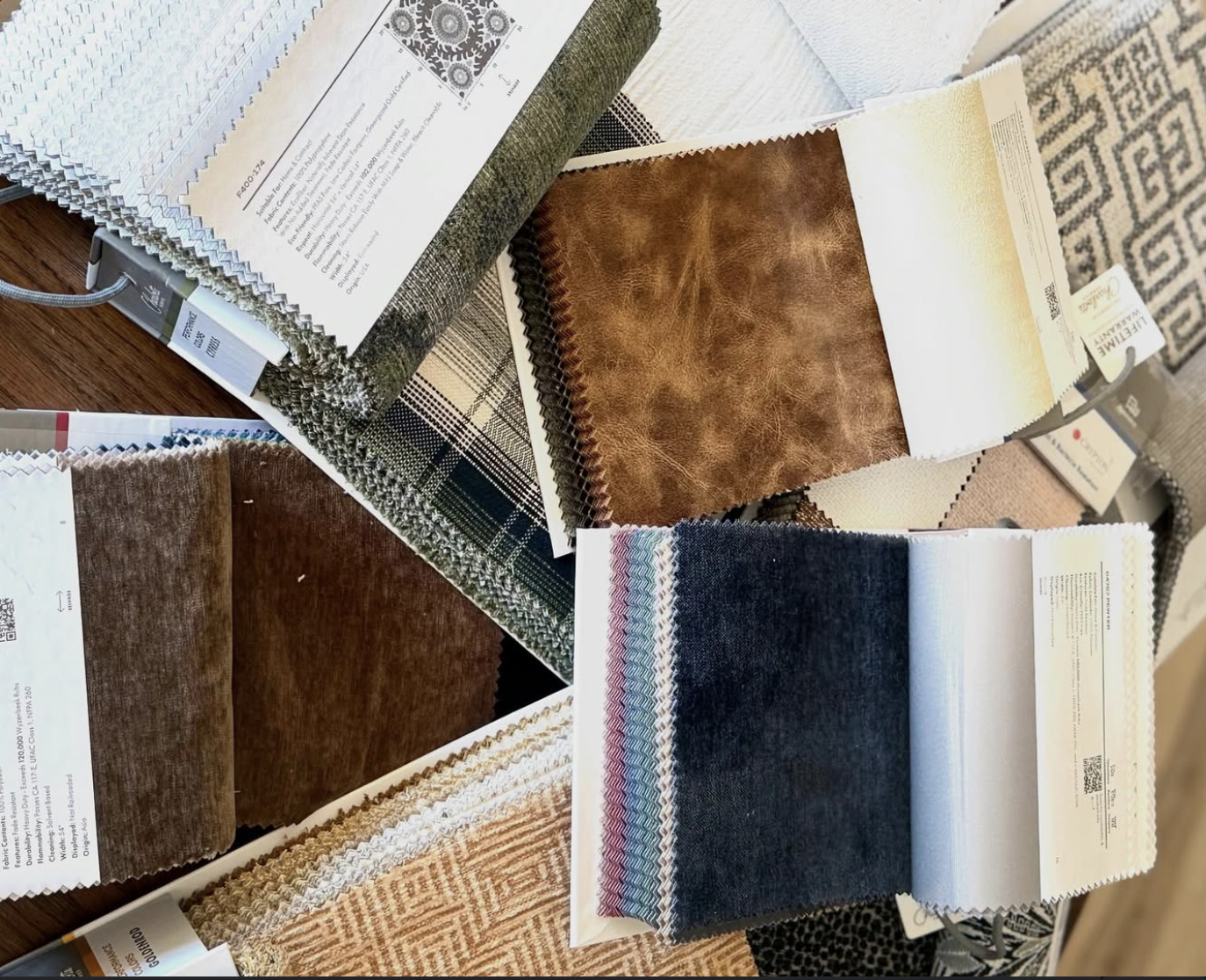 An array of fabric and leather swatches laid out across the studio table