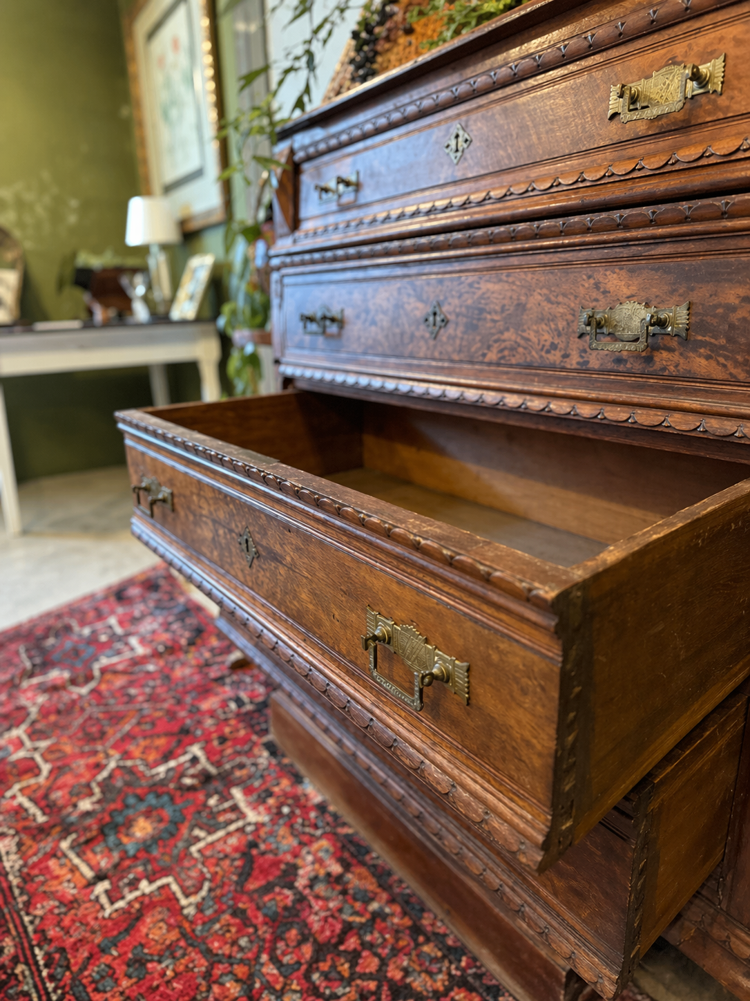Hand-restored antique oak chest of drawers with carved detailing and brass hardware in a Knoxville studio