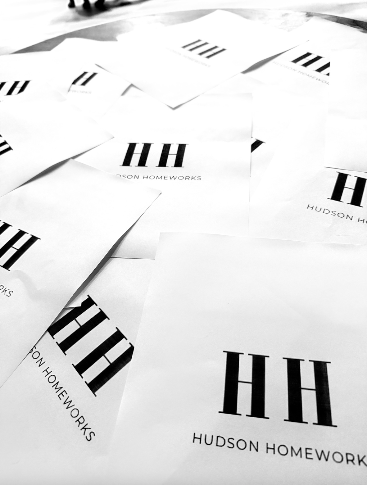 Hudson Homeworks printed logo cards scattered across the studio floor