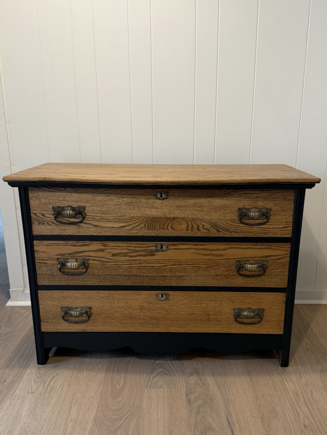 Refinished oak chest of drawers with blackened frame and brass pulls